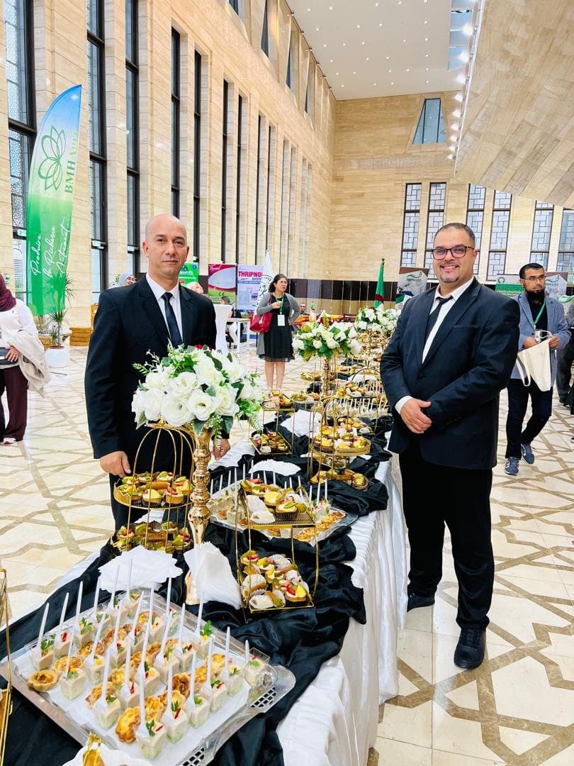 Deux membres de l'équipe de part et d'autre d'un buffet lors d'un événement professionnel.