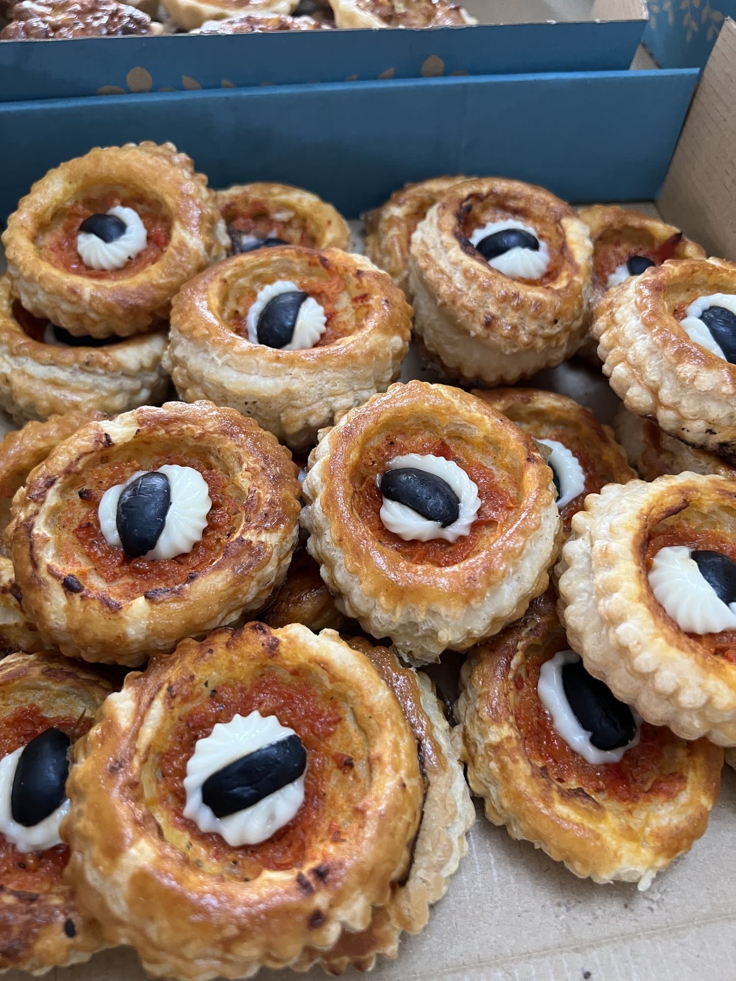 Des bouchées feuilletées à la tomate, garnies d'olive noire.
