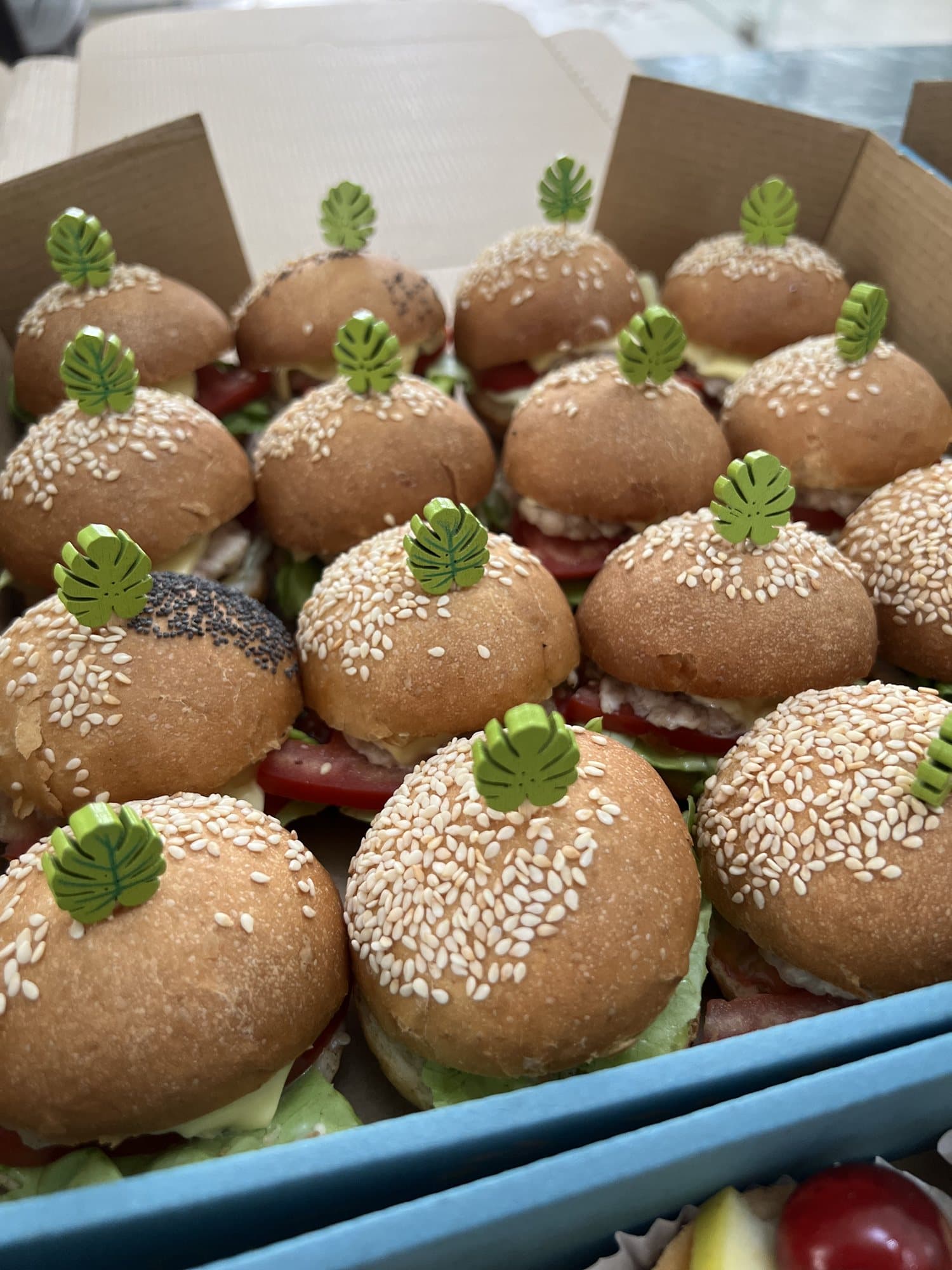 Une boîte de mini-burgers au sésame prêts à être servis.