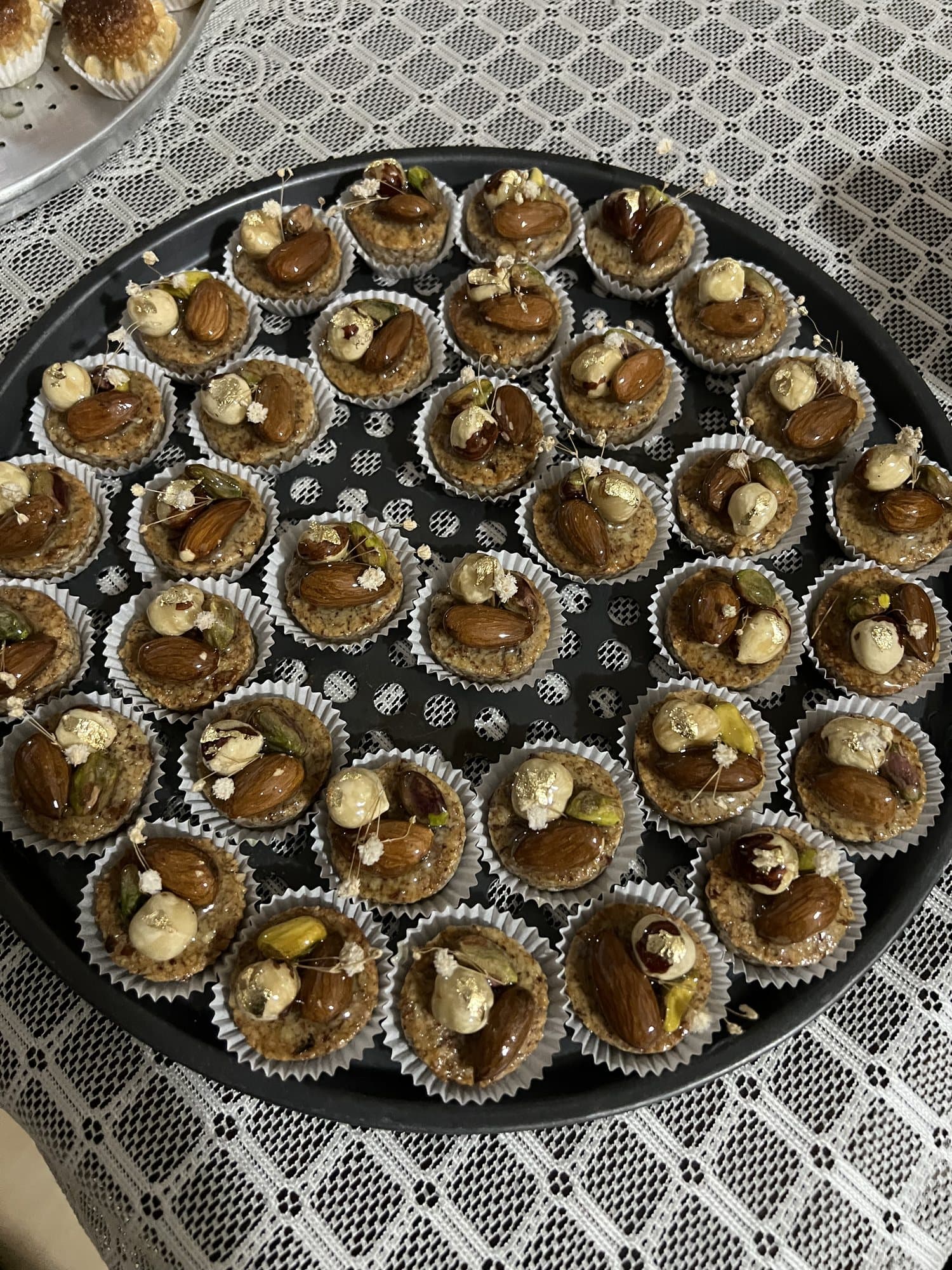 Un plateau de petits gâteaux garnis d'amandes et de noisettes.