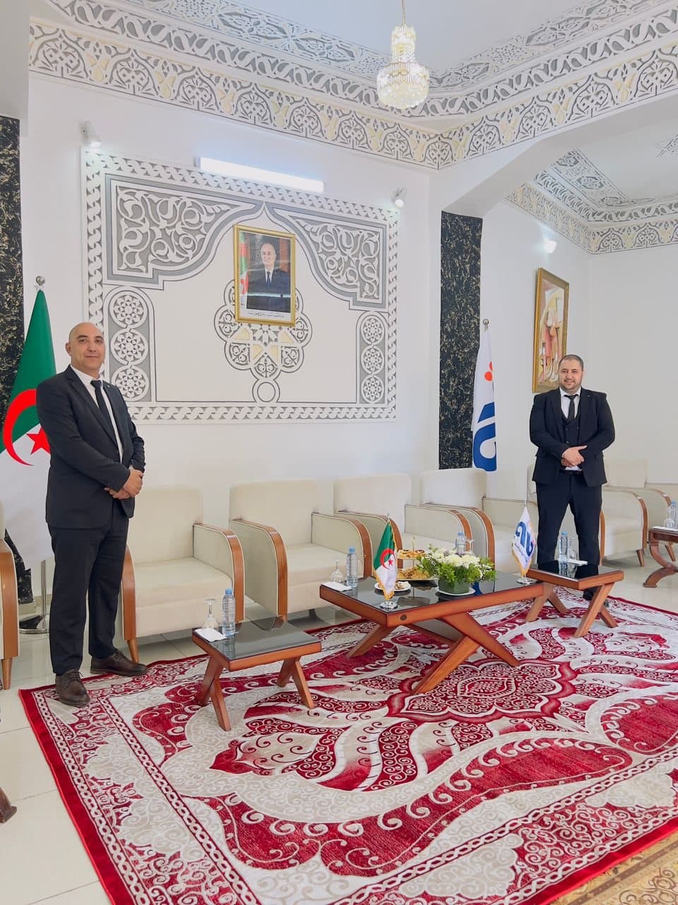 Deux membres de l'équipe dans un salon d'honneur au décor traditionnel, tables de service dressées.